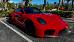 Red Porsche 911 with glossy PPF finish parked in Florida sunlight
