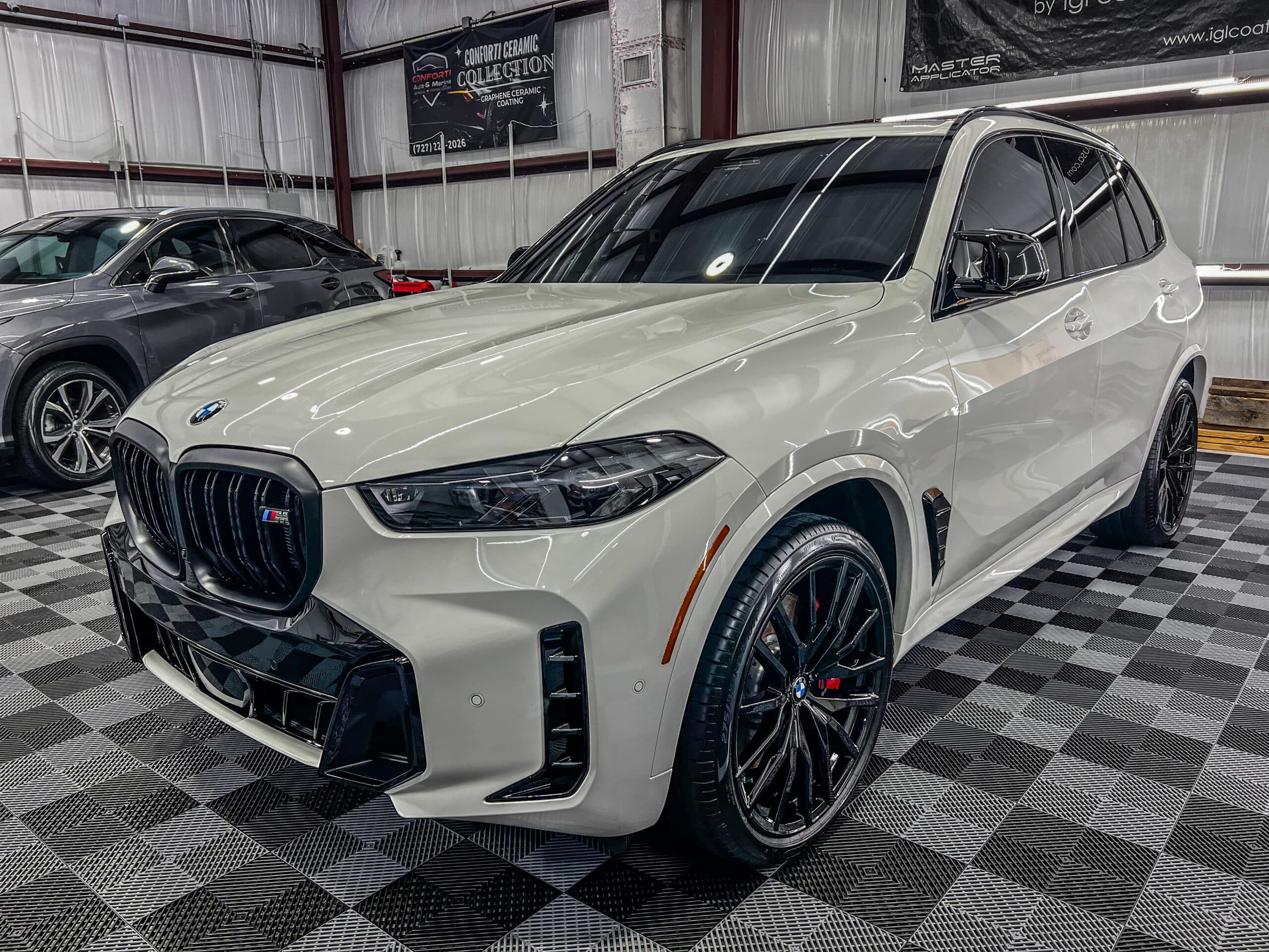 White BMW X5 M Sport with black wheels receiving PPF Tampa detailing service