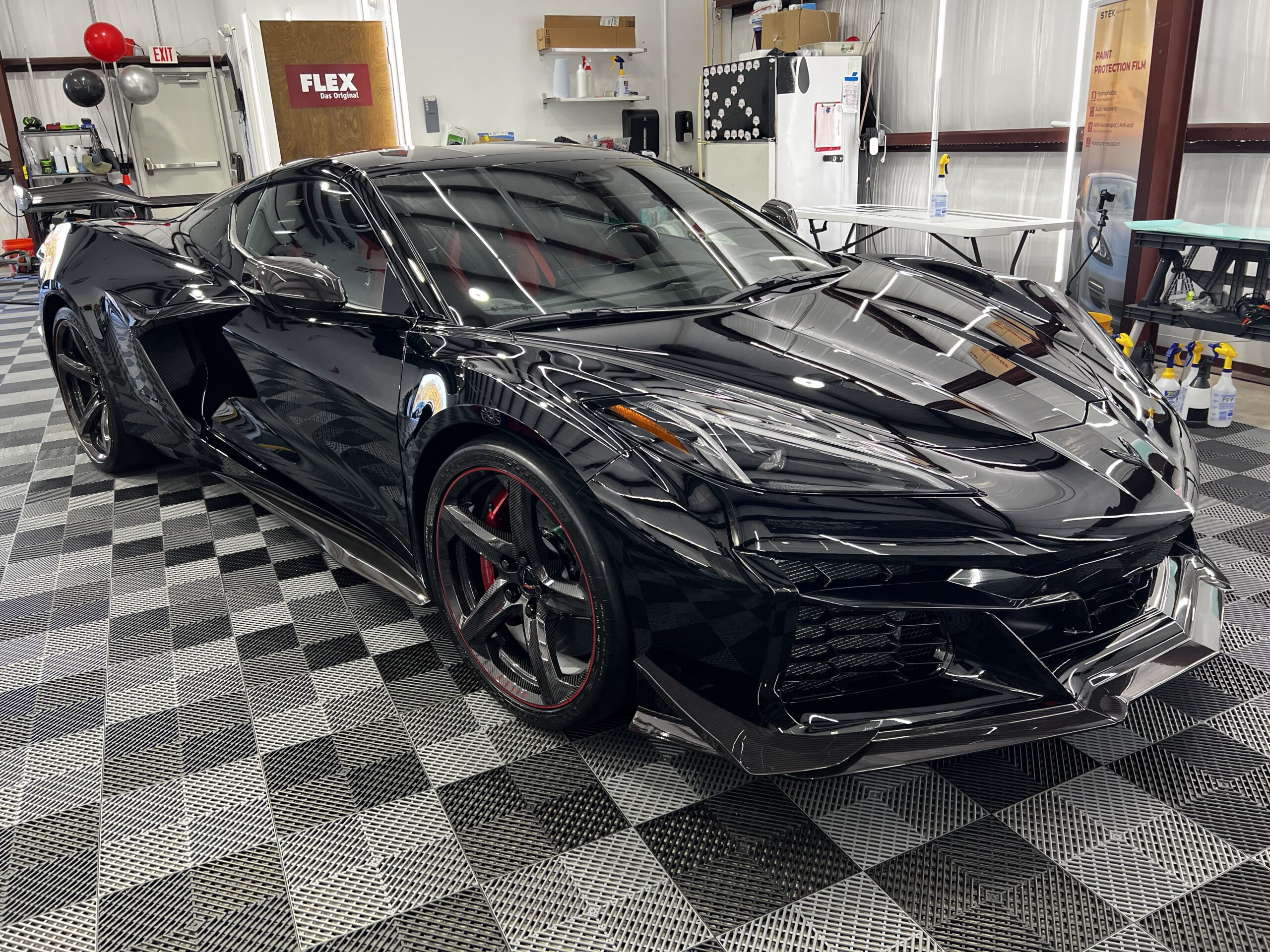 PPF Tampa: Get a Free Quote and What Jeremy Needs 6 Black Chevrolet Corvette Z06 getting PPF Tampa detailing service in professional shop